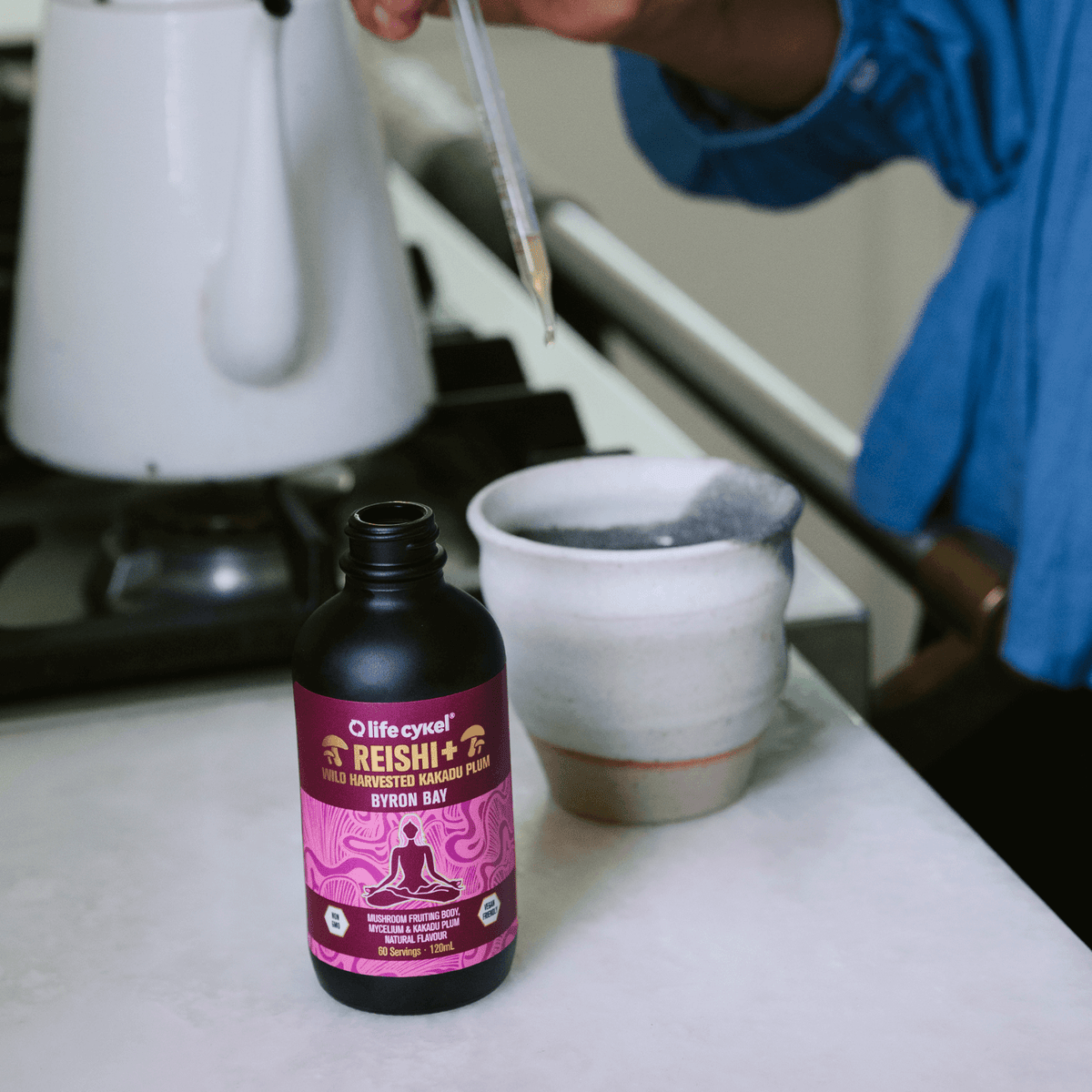 Lifecykel Reishi mushroom extracts supplements with dropper pouring the liquid to the ceramic cup