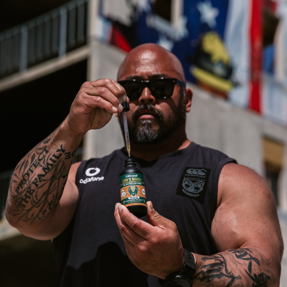 Man holding a bottle of Lifecykel Lion's Mane mushroom extracts supplements with dropper