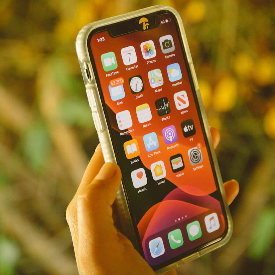 A hand holding a phone with screen on