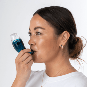 Woman wearing white tops using the blue breathing device