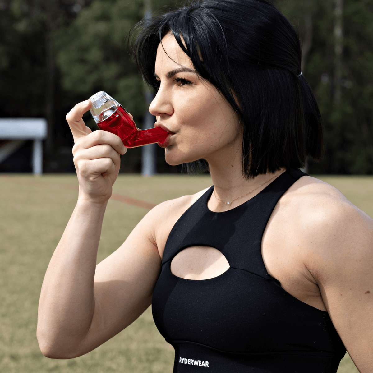 Woman with black tops using the red breathing device 