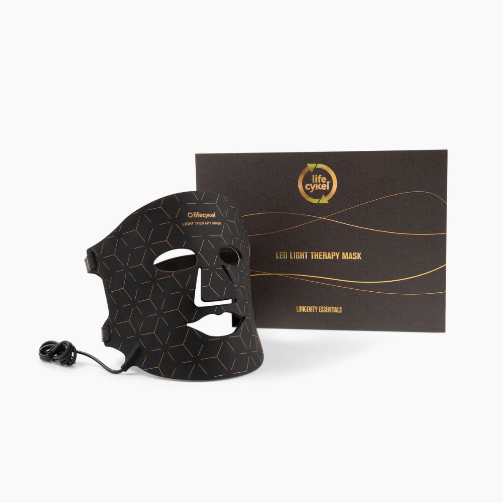 Black LED light therapy mask with packaging on a white background