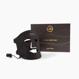 Black LED light therapy mask with packaging on a white background