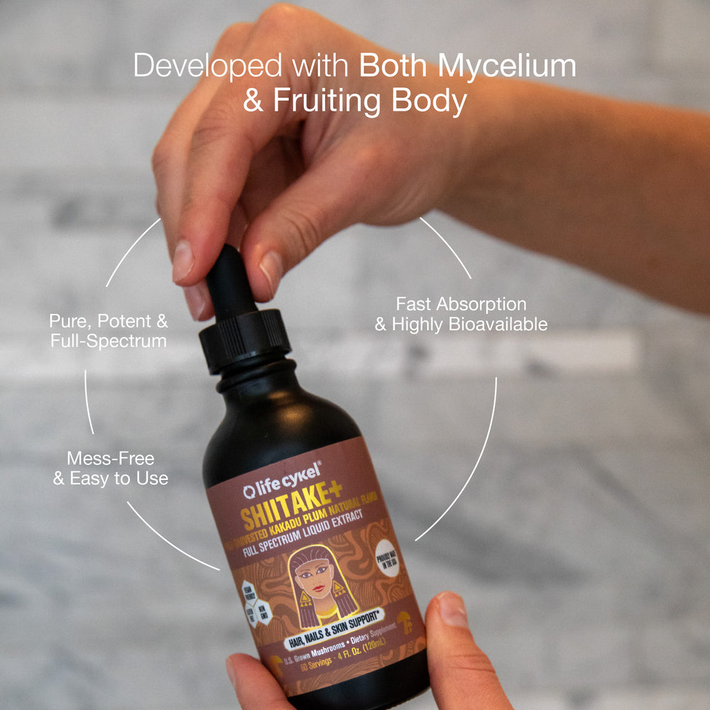 Bottle of Lifecykel Shiitakes mushroom extracts supplements liquid extract with a hand holding it, on a neutral background.
