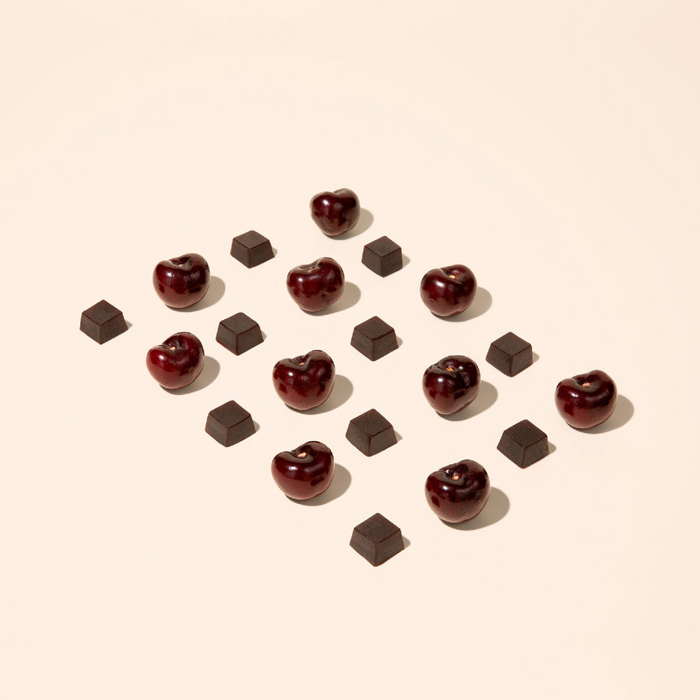 Cherries and gummy cubes pieces arranged in a pattern on a beige background